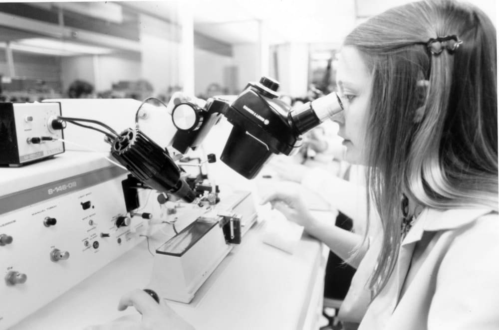 Quality control inspector examining a product using a microscope