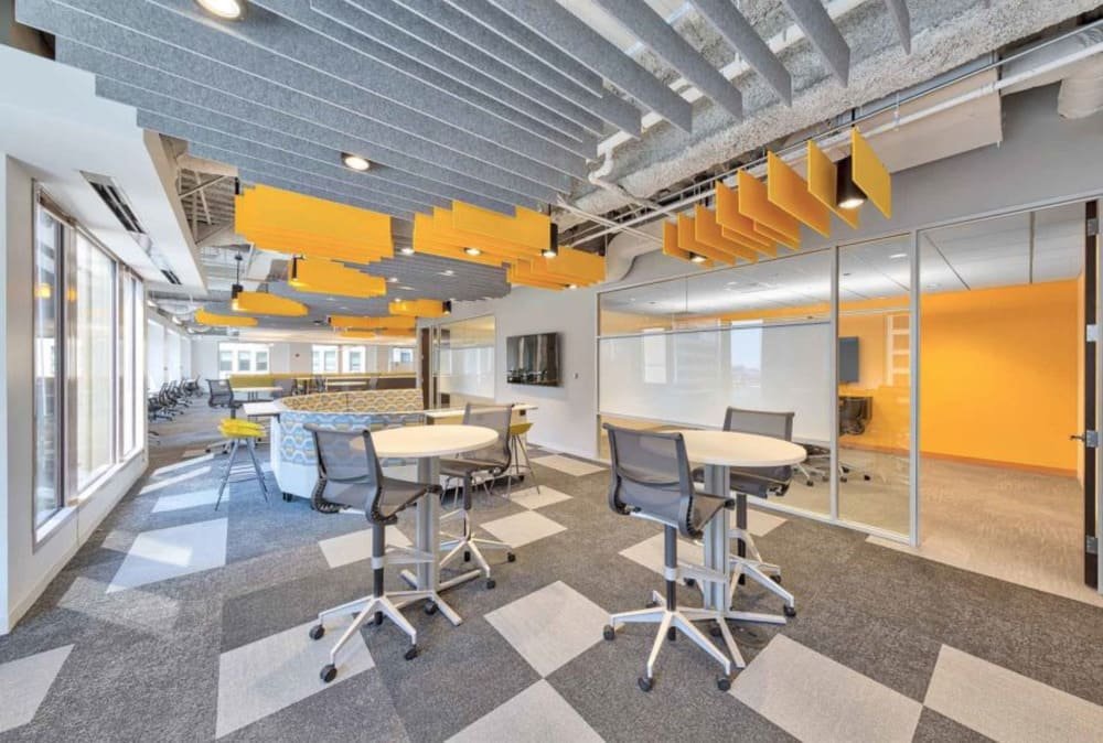 Modern office lounge with gray and orange accents and PET felt acoustic panels
