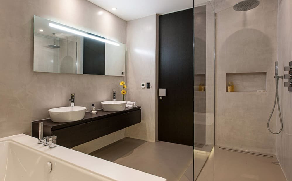 Modern bathroom with glass shower, double sink dark wood vanity, and bathtub