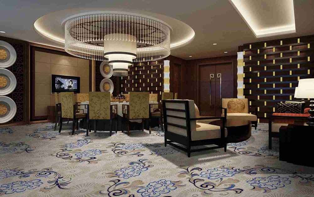 Luxurious dining area with chandelier, patterned carpet, and plush seating 